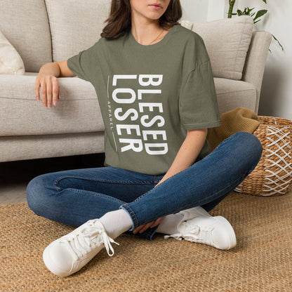 Blessed Loser T-Shirt | Vertical Bold Text Graphic Tee worn by a woman sitting on a sofa with a casual outfit