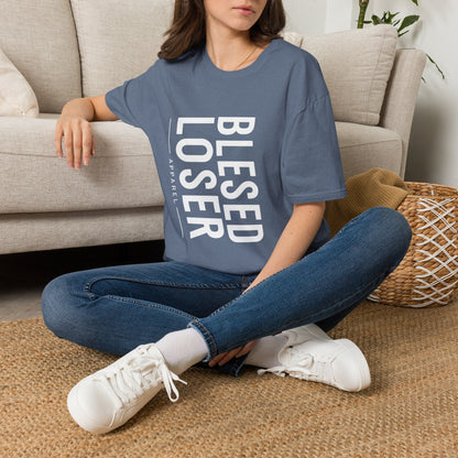 Blessed Loser T-Shirt | Vertical Bold Text Graphic Tee worn by a woman sitting on the floor against a couch.